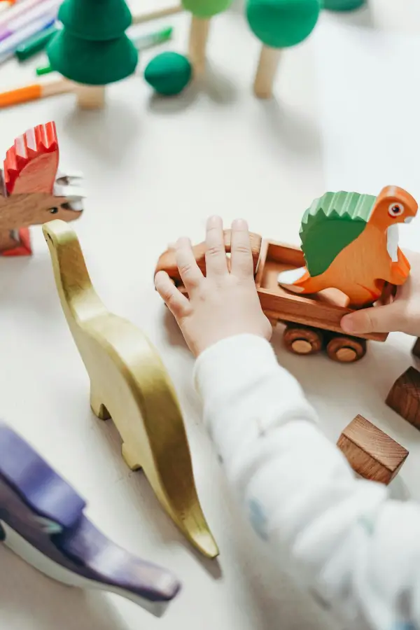 Toddler playign with wooden animals (1)